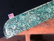 Close up of teal floral wear leather on black saddle pad laid on a pallet